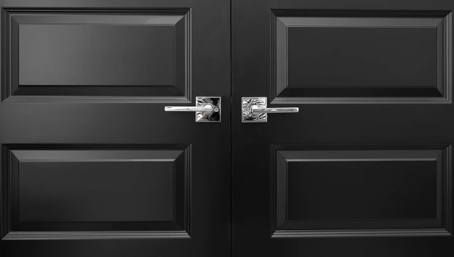 Black interior closet doors with chrome hardware in a home with white walls and white trim